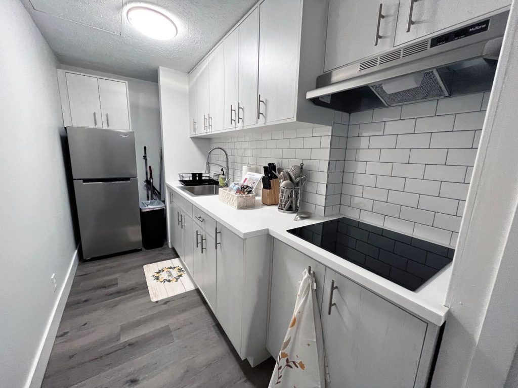Woodgate Apartments, Johnstown, OH: renovated kitchen with white cabinets, subway tile and induction cooktop
